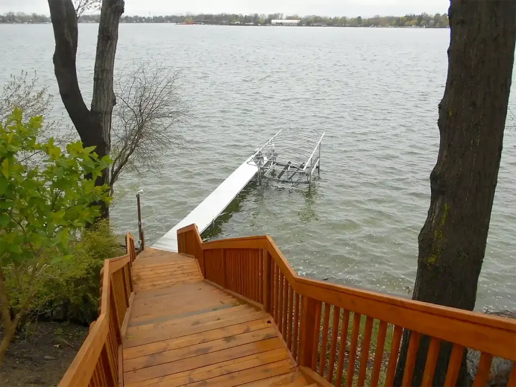 Permanent deck staircase leading down to seasonal dock and boat lift